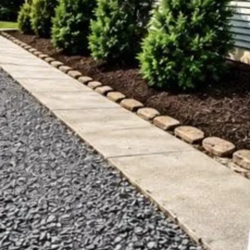 Walkway lined with decorative grey stone and a stone-edged planting bed